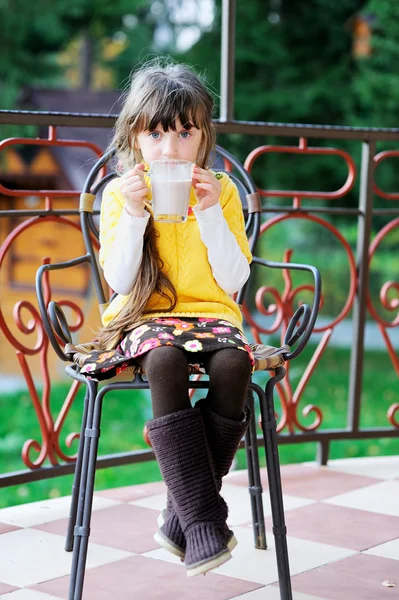 Roztomilé dítě dívka sedící s šálkem čaje venku — Stock fotografie