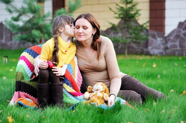 Młoda matka siedzi z córką na trawnik — Zdjęcie stockowe
