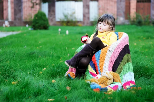 Funny niña comiendo manzana al aire libre — Foto de Stock