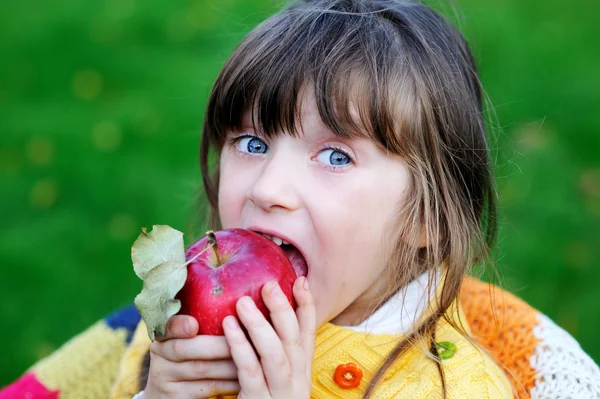 Grappige kind meisje eten apple buitenshuis — Stockfoto