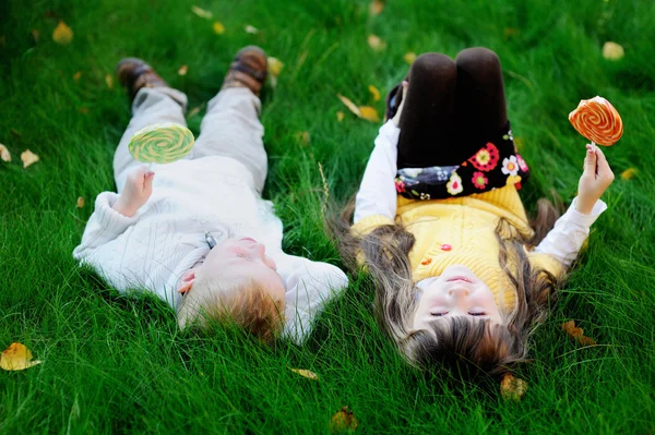 Küçük arkadaşların lolipop, birlikte bir çim yeme — Stok fotoğraf