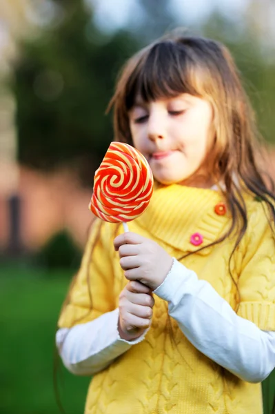 Portrait of cute little girl eating big lollipop — Stock Photo, Image