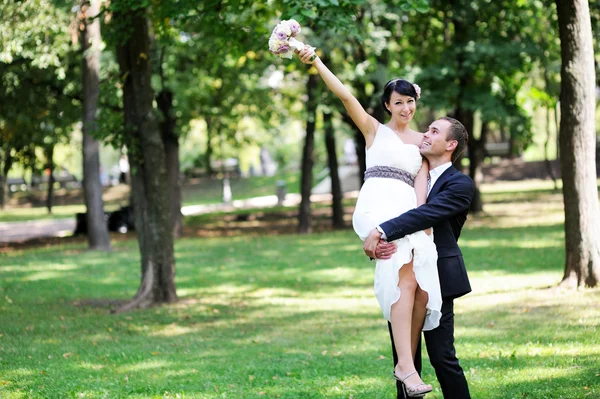 Feliz noivo com noiva em seus braços — Fotografia de Stock