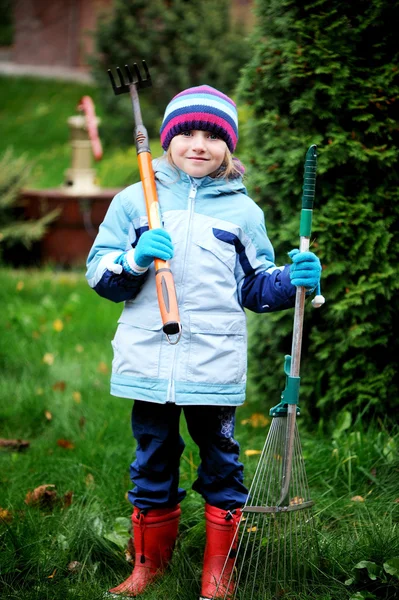 Lilla flickan arbetar i höst trädgården — Stockfoto