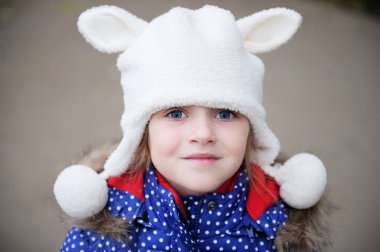Outdoors portrait of a child girl in warm hat clipart