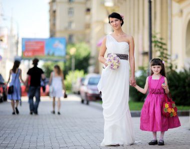 Beautiful bride posing together with flowergirl clipart