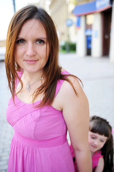 屋外でポーズ ピンクのドレスで美しい母 — ストック写真