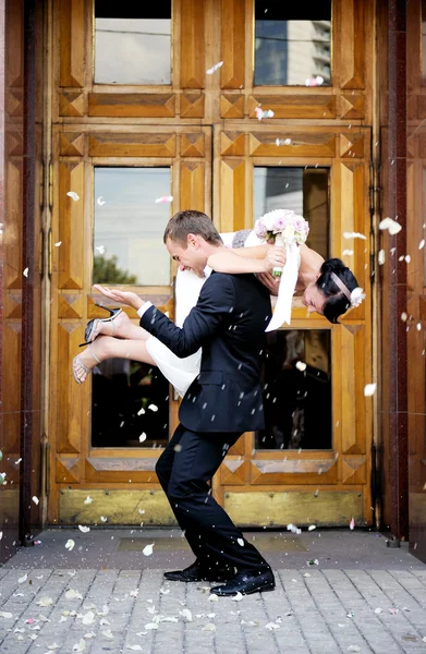 Just married couple showered in rose petals — Stock Photo, Image