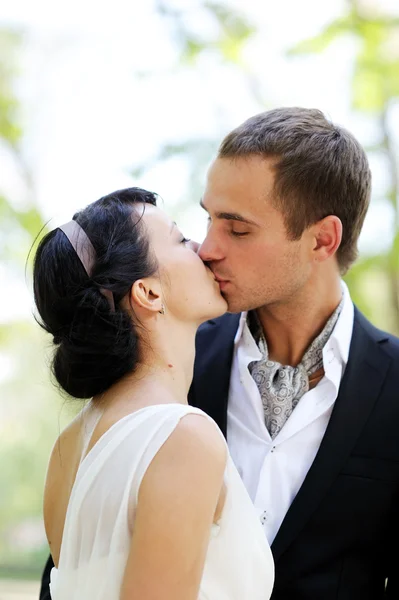 Noiva e noivo se beijando ao ar livre — Fotografia de Stock