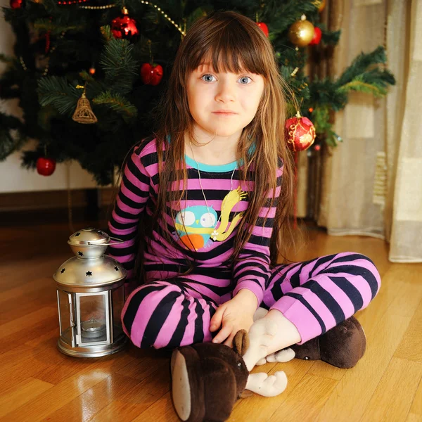 Portret van meisje onder kerstboom — Stockfoto