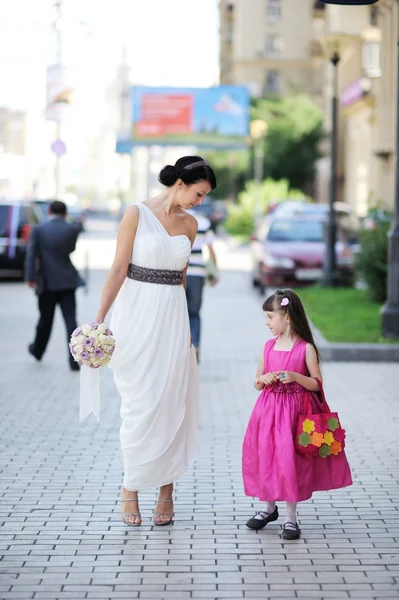 Schöne Braut posiert zusammen mit Blumenmädchen — Stockfoto