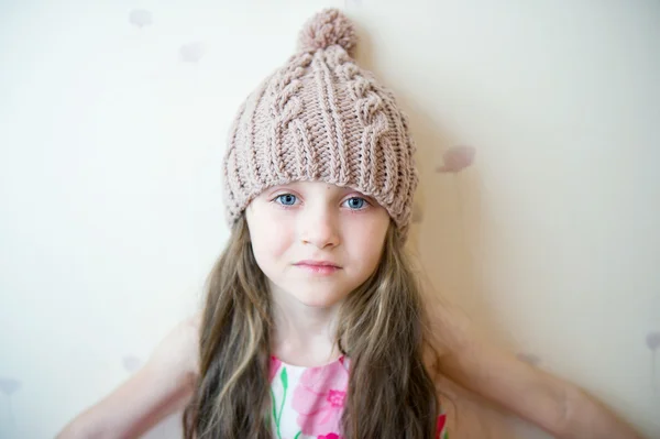 Adorable niña sonriente en beige sombrero de punto — Foto de Stock