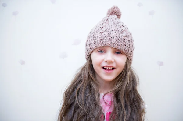 Bedårande leende barn flicka i beige Stickad mössa — Stockfoto