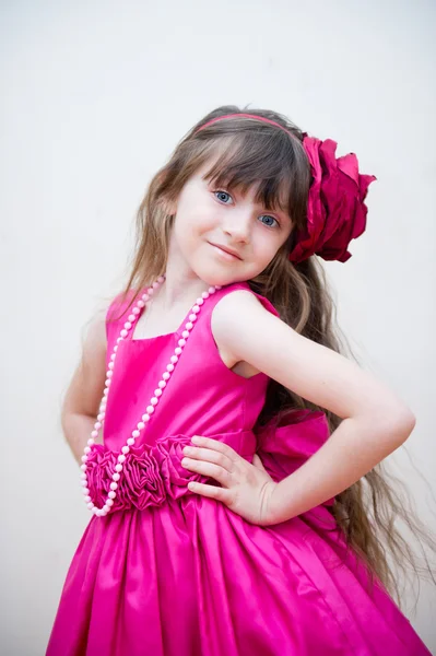 Красивая маленькая девочка в красивом розовом платье — стоковое фото