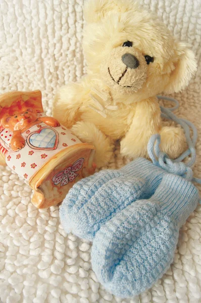 Teddybär und blaue Fäustlinge — Stockfoto