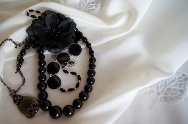 Necklace and black fabrics flower — Stock Photo, Image