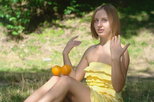 The girl on the nature with oranges — Stock Photo, Image