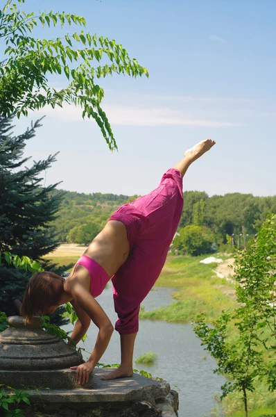 Flickan är engagerad i yoga på natur — Stockfoto
