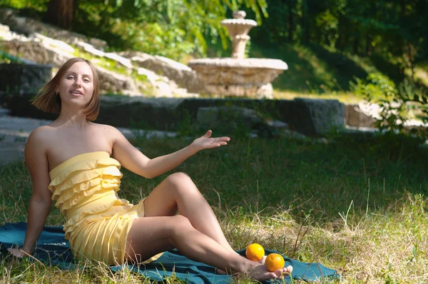 stock image The girl on the nature with oranges