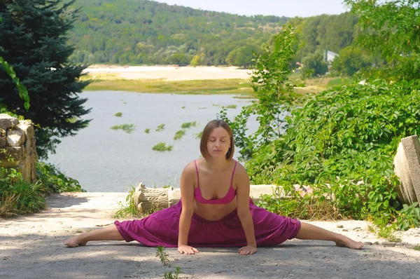A menina está envolvida em ioga sobre a natureza Fotos De Bancos De Imagens