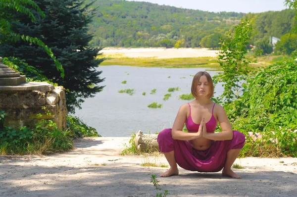 La muchacha se ocupa del yoga sobre la naturaleza Fotos de stock