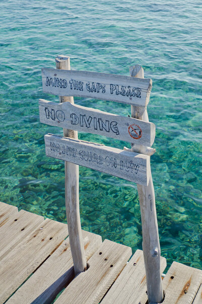 Danger wooden sign on Maldivian jetty