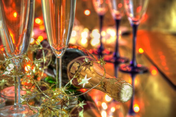 Closeup of champagne in glasses,bottle and blurred lights on background.