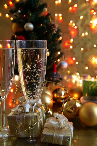 Champagne in glasses and gifts on gold background — Stock Photo, Image