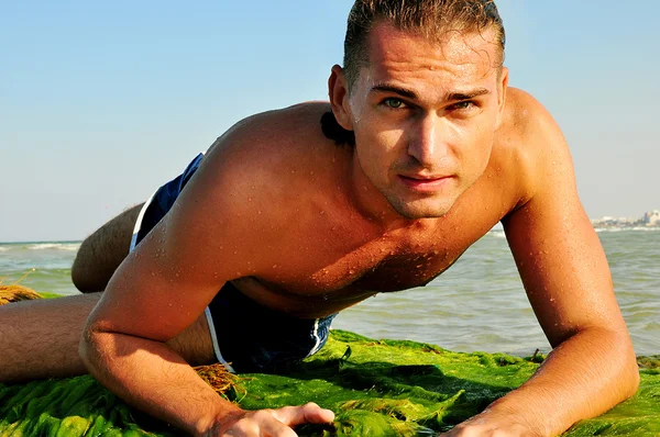 Сексуальный мужчина позирует на пляже Лицензионные Стоковые Фото