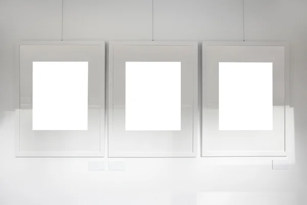 Molduras em branco na galeria de arte parede branca — Fotografia de Stock