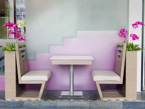 Table and chair in restaurant with flowers Stock Photo