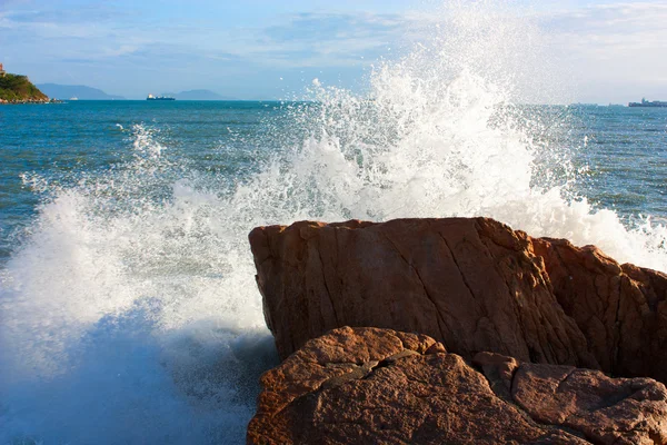 A hullámok törés egy köves strandon, alkotó nagy spray Jogdíjmentes Stock Fotók