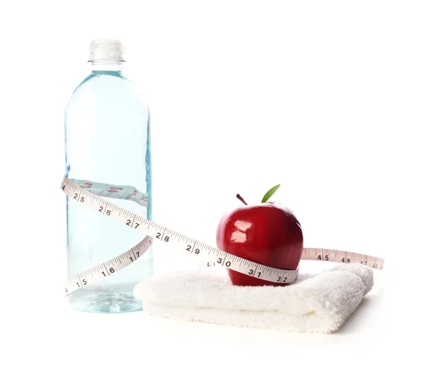 Butelka wody z jabłkiem i taśma pomiarowa — Zdjęcie stockowe
