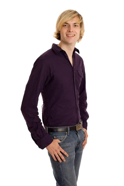 Ung man i lila skjorta och jeans. Studio skott över vita. — Stockfoto
