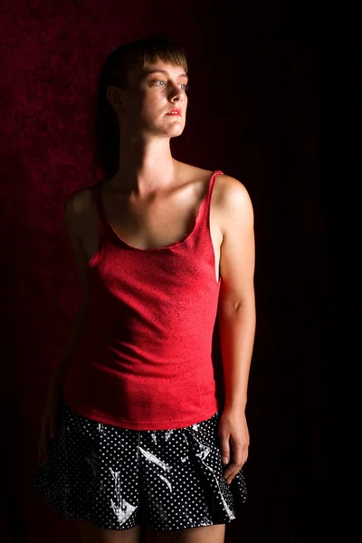 ALT mode vrouw. humeurig studio opname over donkerrood. — Stockfoto