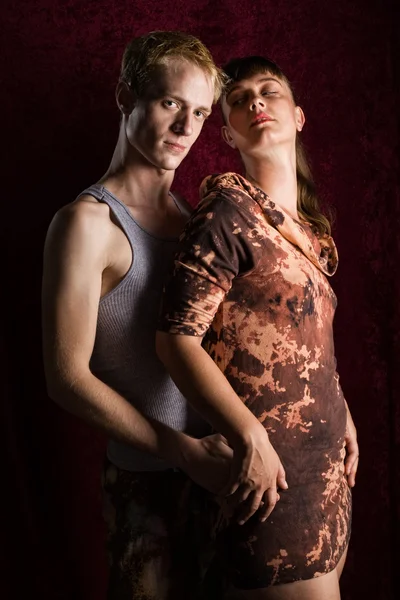 Alt fashion couple. Moody studio shot over dark red. — Stock Photo, Image