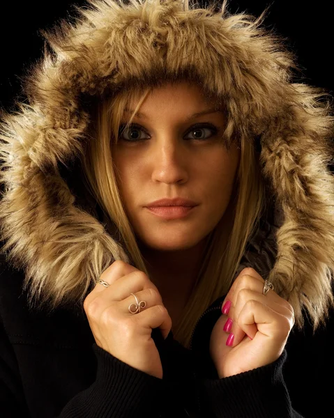 stock image Young woman in winter Jacket. Studio shot over black.