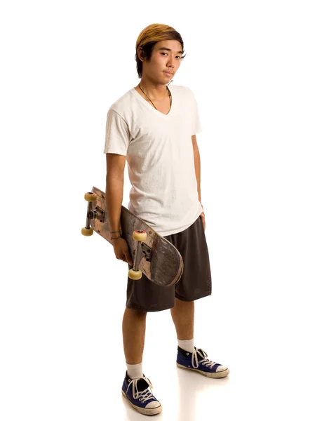 Junger Mann mit Skateboard. Studioaufnahme über Weiß. — Stockfoto