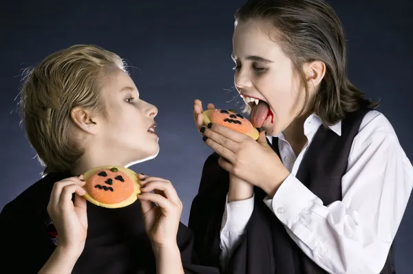 Мальчики едят печенье на Хэллоуин — стоковое фото