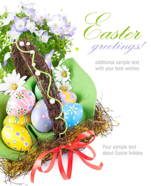 Easter eggs in basket with spring flowers — Stock Photo, Image