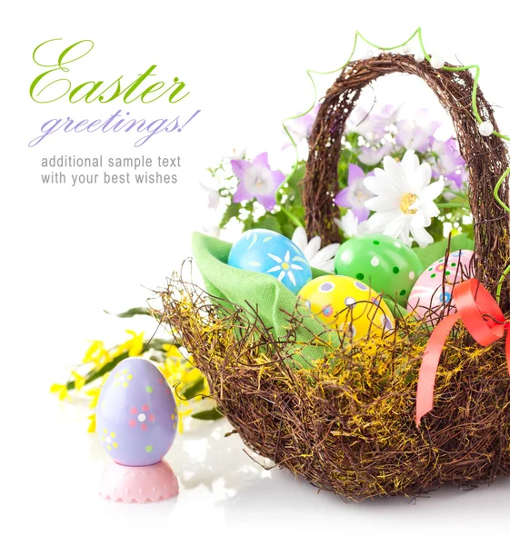 Ovos de Páscoa em cesta com flores de primavera — Fotografia de Stock