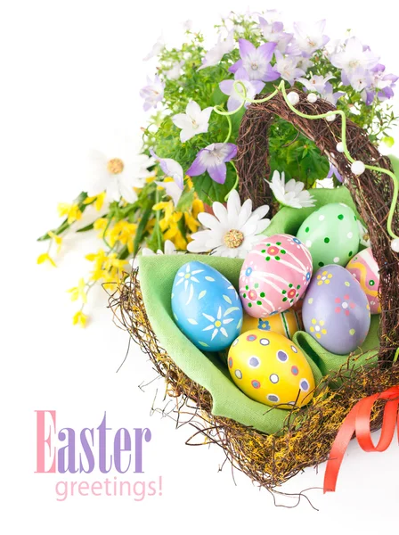 Uova di Pasqua in cesto con fiori primaverili — Foto Stock