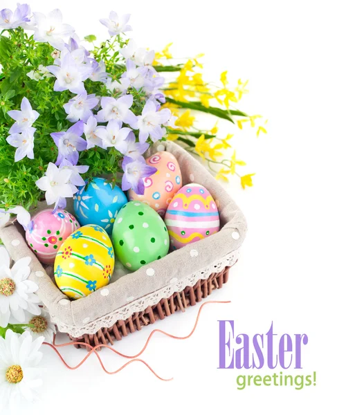 Великодні яйця в кошику з весняними квітами — стокове фото