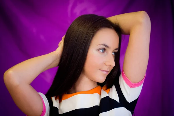 Vrouw tegen paarse achtergrond — Stockfoto