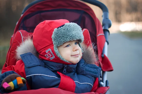 Kırmızı bebek arabası içinde sarılı bebek — Stok fotoğraf