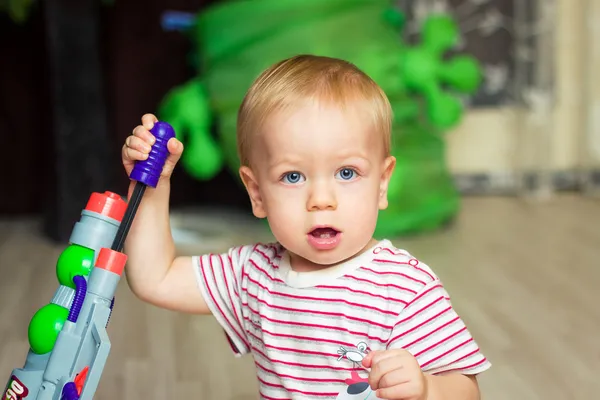 Bebê com arma de brinquedo — Fotografia de Stock
