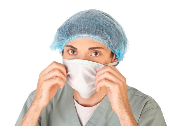 Молодой доктор в маске и медицинской шапке — стоковое фото