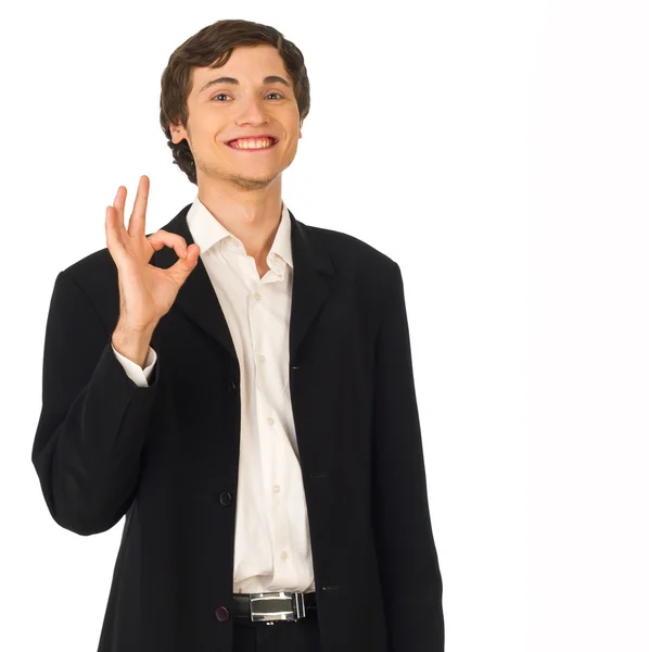 Mladý obchodník usmívá a ukazující pořádku gesto — Stock fotografie