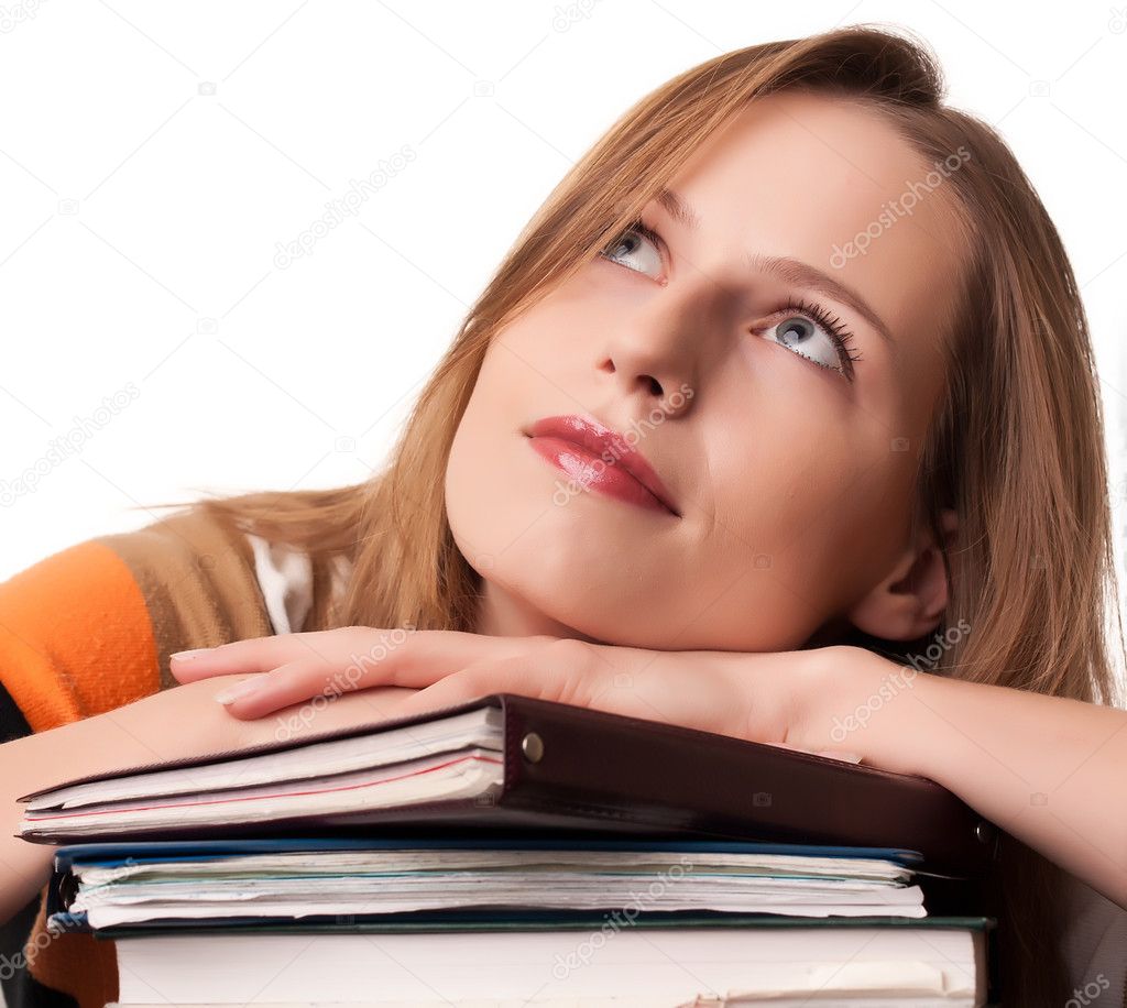 Young girl student with pile of books dreaming