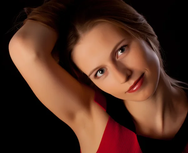 Schöne junge Frau hebt die Hand und spielt mit ihren Haaren — Stockfoto